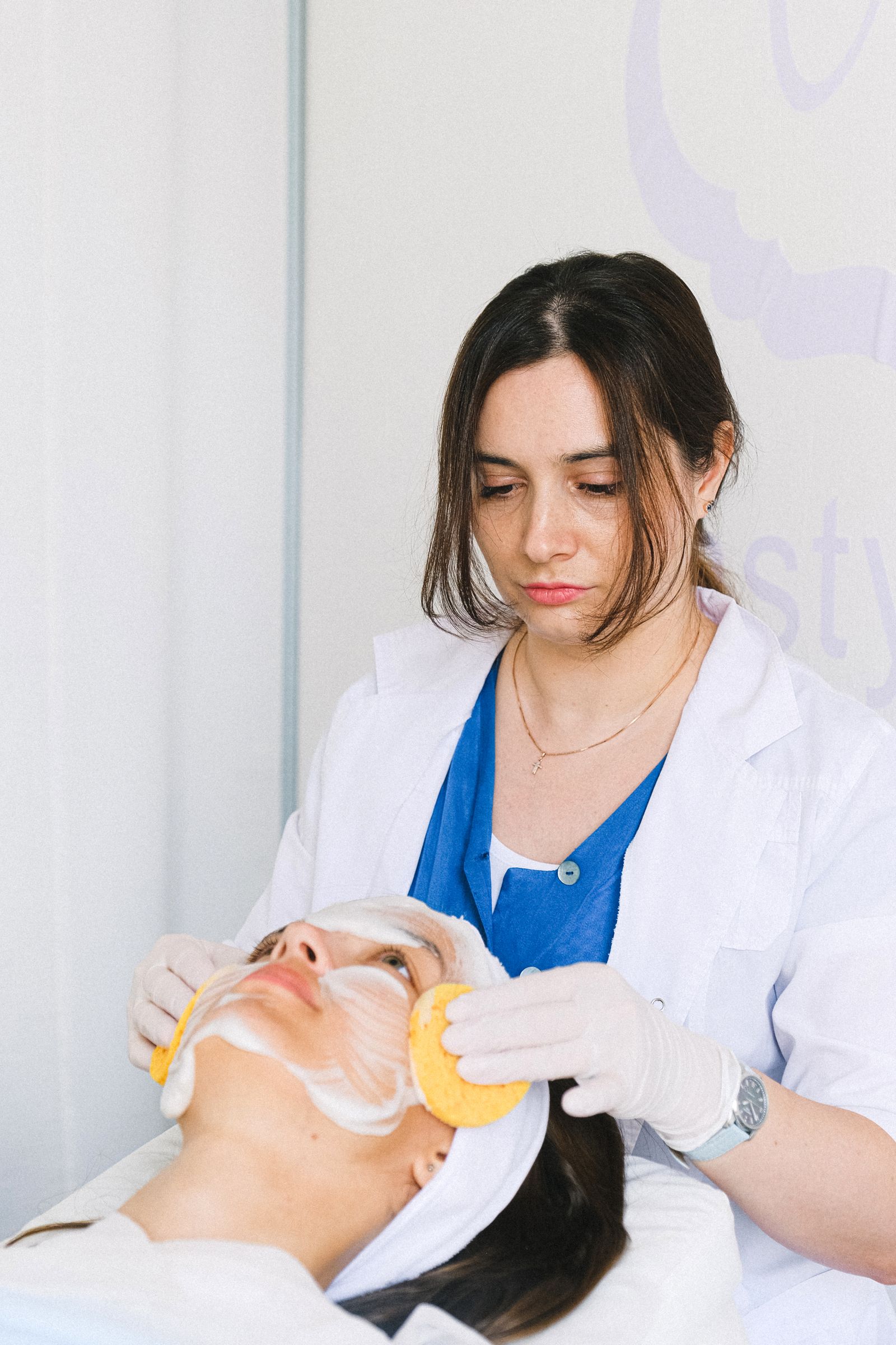 Cosmetóloga realizando um tratamento facial em uma mulher em uma clínica de estética.
